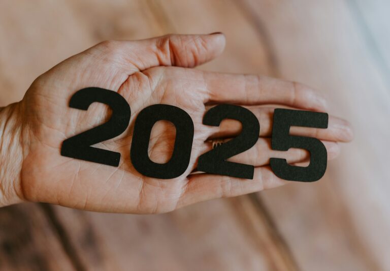 A hand holding figures spelling 2025.