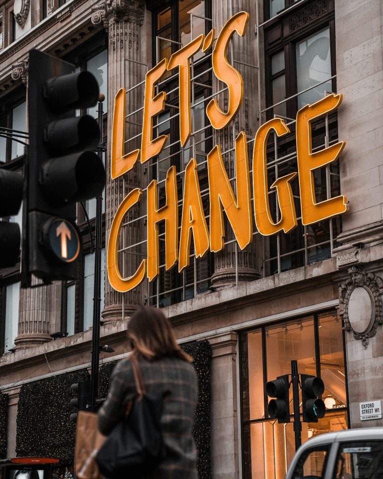 A sign on the side of a building says "let's change".