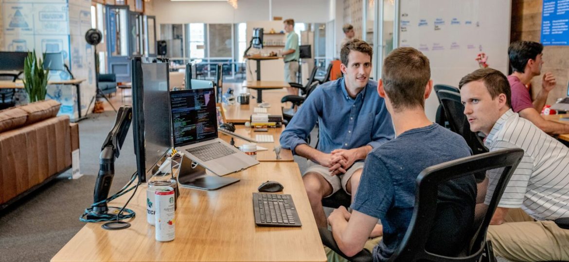 A group gathers around a trendy office table