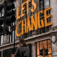 A sign on the side of a building says "let's change".
