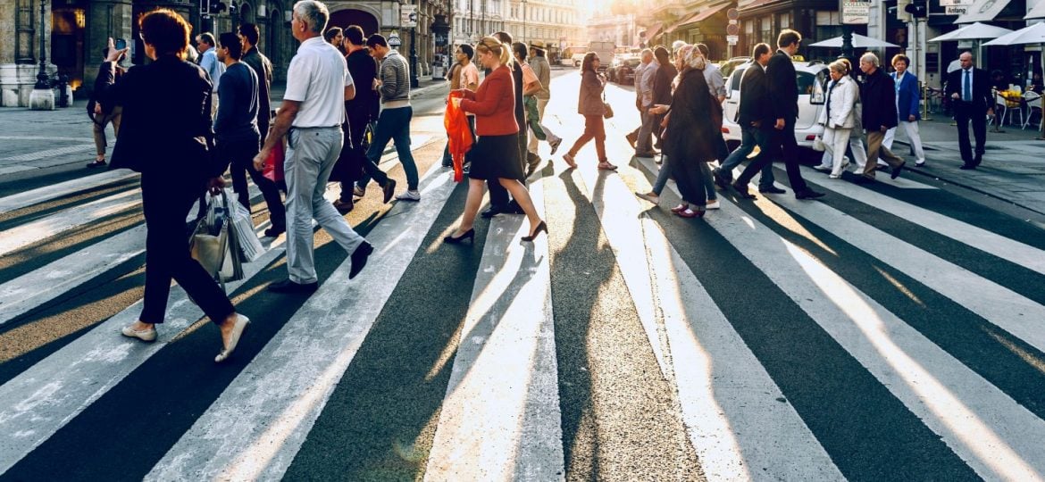 Lots of people cross at pedestrian crossing.